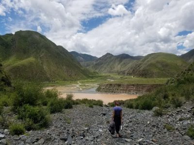 Women standing in front of a lake with mountains in the background in Tibet