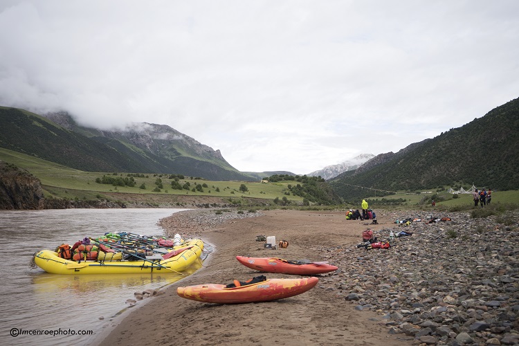 Rafts, Kayaks and Watershed Drybags parked on the shore in the mountains of Tibet 