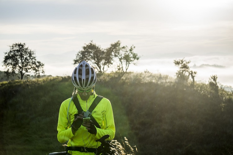 Man wearing a helmet outside while he checks his phone