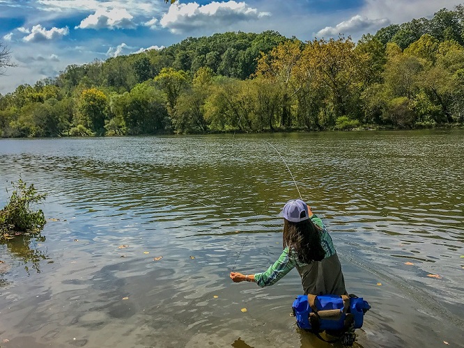 Women fishing in the water with a Watershed Drybag Goforth on her hip