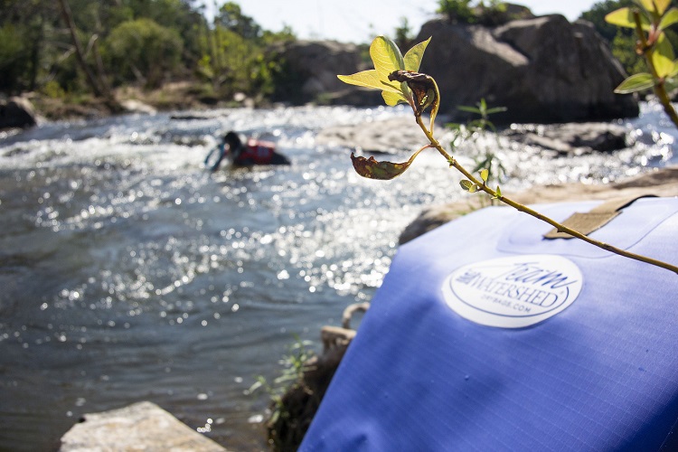 Team Watershed logo on the backpack in the water 