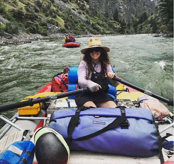 Women rowing a raft down the river with a large Watershed Drybag up front