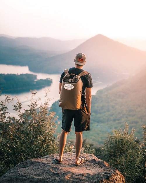 Man wearing an Animas backpack while overlooking a river 