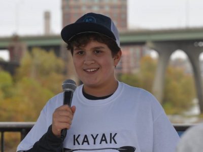 Nathaniel Milligan smiling and talking into a microphone