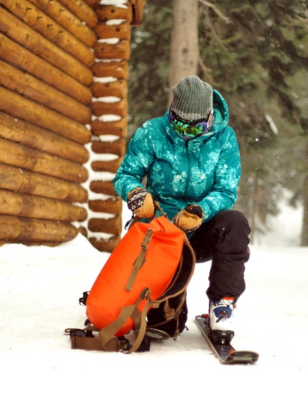 Person in skies opening the Animas Backpack